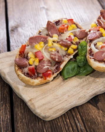 Portion of Salami Pizza Baguette on wooden backgroundの写真素材