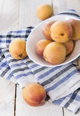 Portion of ripe Apricots in a small bowlの写真素材