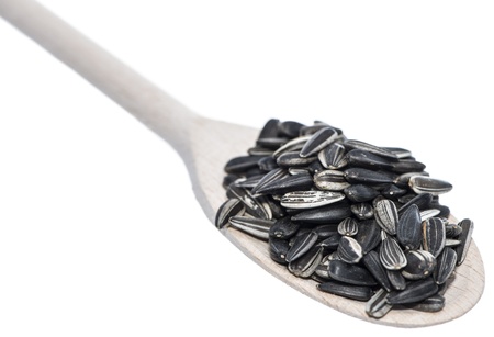 Sunflower Seeds on a wooden spoon (isolated on white background)の写真素材