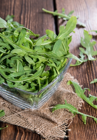 Portion of fresh Arugula Salad on wooden backgroundの写真素材