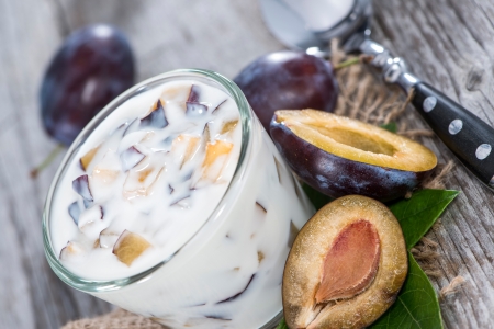 Homemade Plum Yogurt with fresh fruits on vintage wooden の写真素材