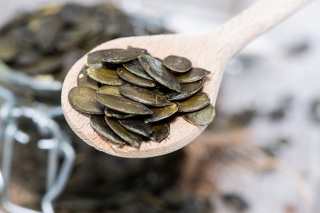 Pumpkin Seeds on wooden Spoon (macro shot)の写真素材