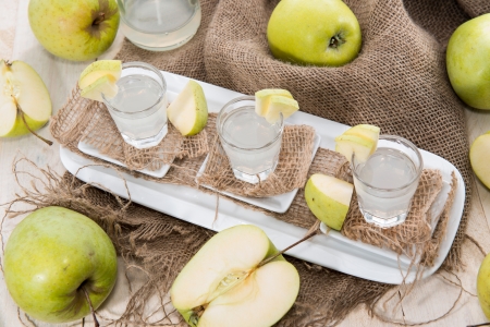 Apple Liqueur in small glasses with fruitsの写真素材