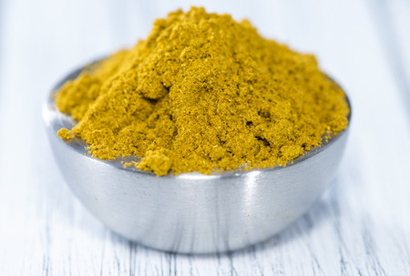 Curry Powder (in a bowl) on white vintage wooden backgroundの写真素材