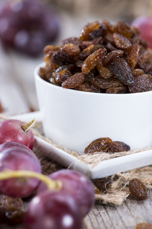 Raisins and Grapes on wooden backgroundの写真素材