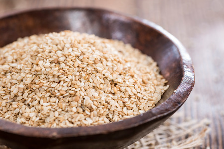 Portion of Sesame in a bowl (on dark wooden background)