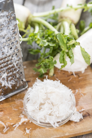 Fresh grated Horseradish on wooden background (detailed close-up shot)の写真素材