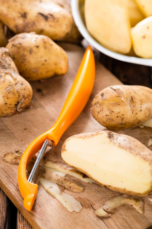 Portion of peeled Potatoes on old wooden tableの写真素材