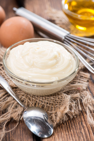 Fresh homemade Mayonnaise on an old wooden table (close-up shot)の写真素材