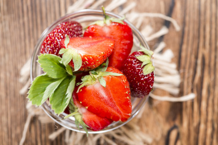 Strawberry Pieces (close-up shot) on dark wooden backgroundの写真素材