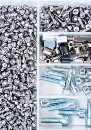 Different Screws and other Parts sorted in a box (close-up shot)