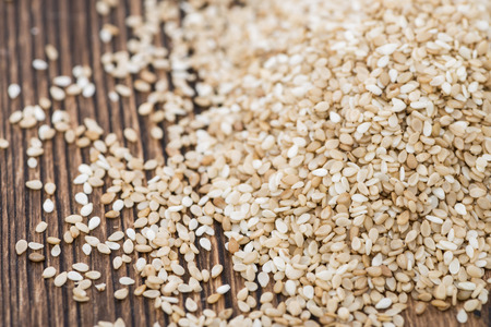 Portion of Sesame Seeds on dark wooden background (close-up shot)