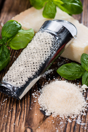 Grated Parmesan Cheese on dark wooden background (detailed close-up shot)の写真素材