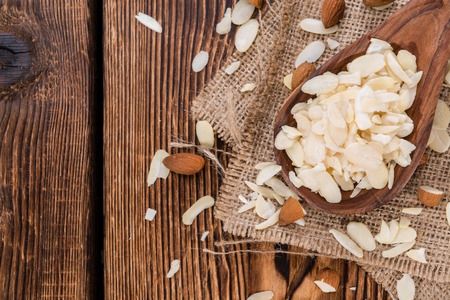Heap of Almond Flakes (detailed close-up shot) on wooden backgroundの写真素材