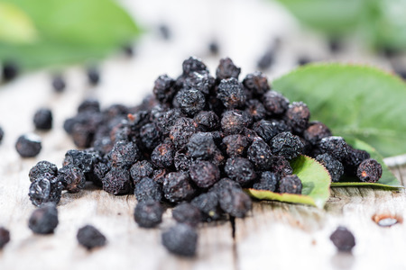 Portion of dried Chokeberries (with leaves) on weatheres wooden backgroundの写真素材