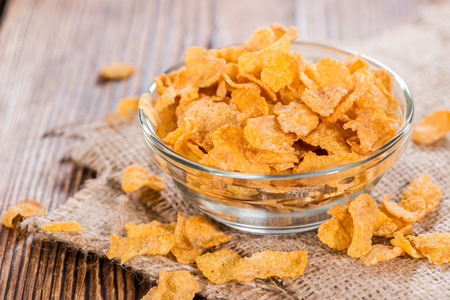 Heap of golden Cornflakes on a rustic wooden table