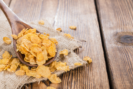 Golden Cornflakes (detailed close-up shot) on an old wooden table