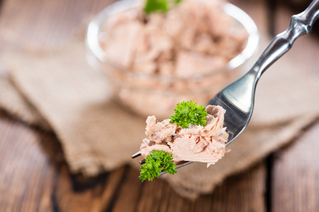 Portion of tuna (with parsley) on a fork as detailed close-up shotの写真素材