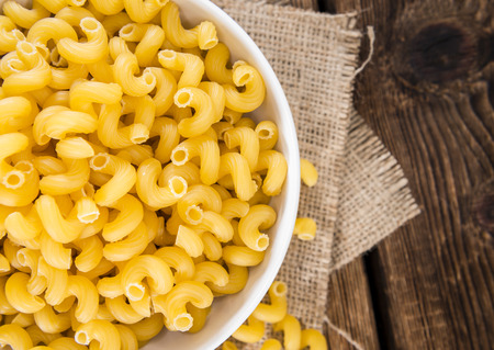 Portion of raw Pasta Curls on wooden backgroundの写真素材