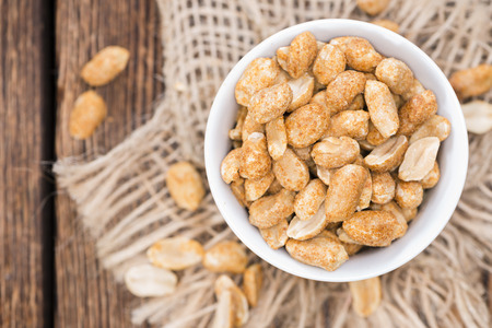 Heap of Peanuts (roasted and salted) on dark wooden background
