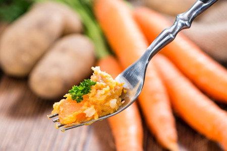 Homemade Carrot Stew (close-up shot; on rustic wooden background)の写真素材