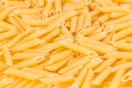 Uncooked Penne (close-up shot) for use as background image or as textureの写真素材