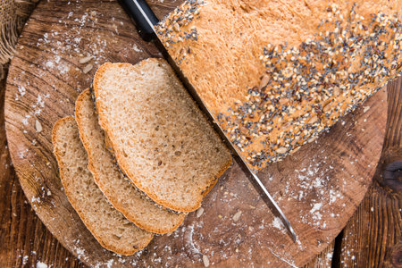 Loaf of bread (fresh baked) on rustic wooden background