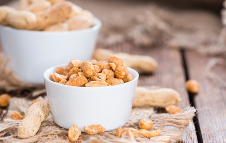 Heap of Peanuts (roasted and salted) on dark wooden background