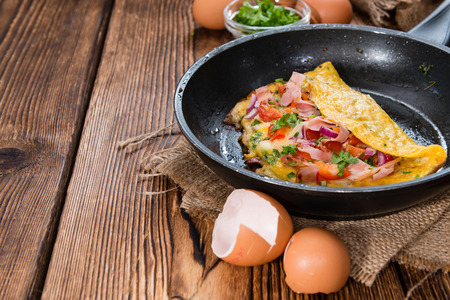 Frypan with Ham and Cheese Omelette on rustic wooden backgroundの写真素材