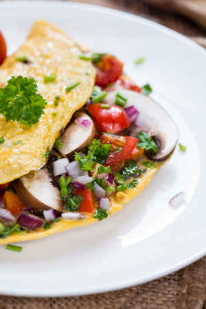 Vegetable Omelette (close-up shot) with fresh mushrooms and herbsの写真素材