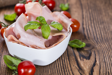 Portion of Ham with fresh herbs (close-up shot)の写真素材