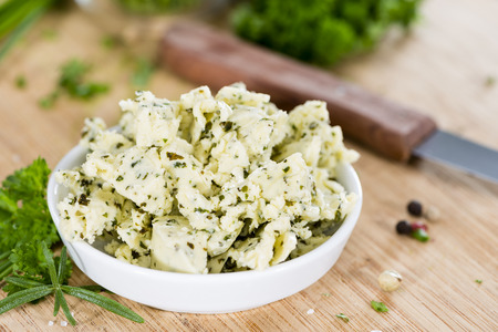 Herb Butter (close-up shot) in a bowl on wooden backgroundの写真素材