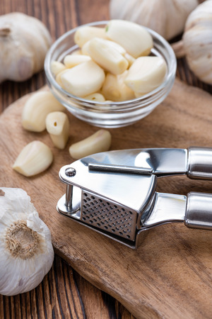 Fresh pressed Garlic (detailed close-up shot) on rustic wooden backgroundの写真素材