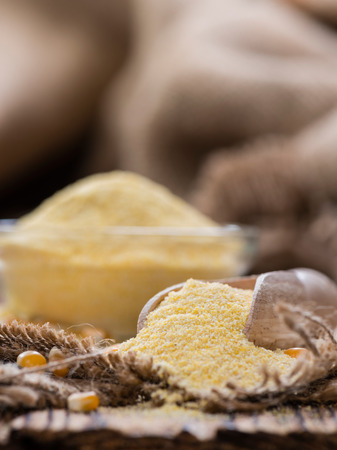 Portion of fresh Cornmeal (close-up shot) on rustic wooden backgroundの写真素材