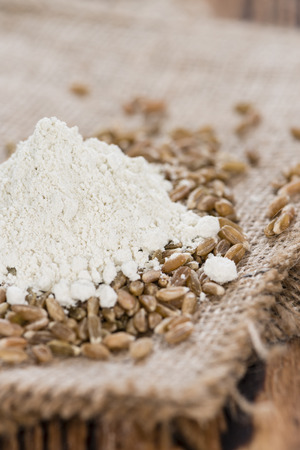 Portion of Spelt Flour (close-up shot) on rustic wooden backgroundの写真素材