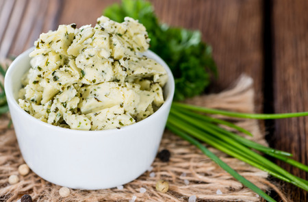 Herb Butter in a small bowl (on wooden background)の写真素材