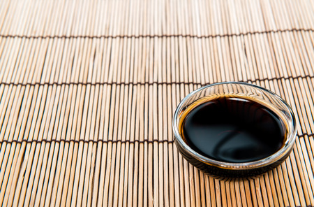Soy Sauce in a bowl (close-up shot) on bamboo backgroundの写真素材