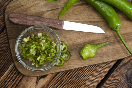 Green Chilis (cutted) on an old rustic wooden tableの写真素材