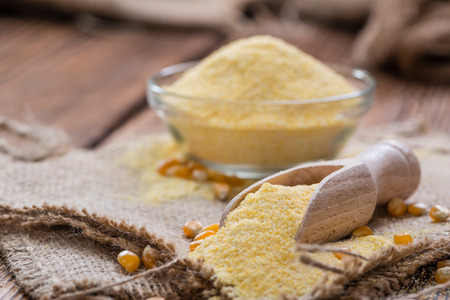 Portion of fresh Cornmeal (close-up shot) on rustic wooden backgroundの写真素材