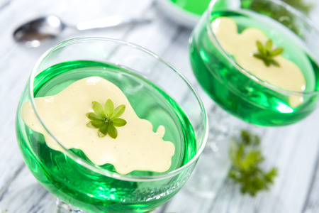 Woodruff Jelly with Vanilla Sauce (on wooden background)の写真素材