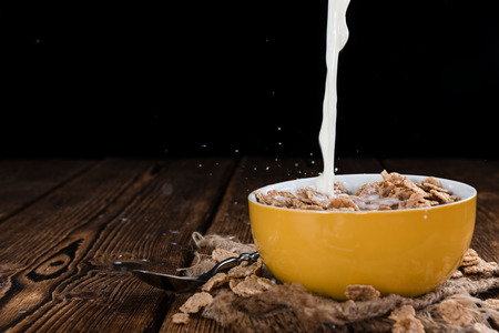 Pouring Milk on a portion of Cornflakes (in a bowl)
