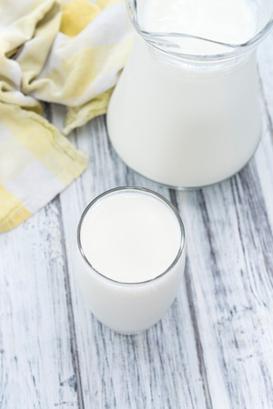 Portion of Milk on wooden background (close-up shot)の写真素材