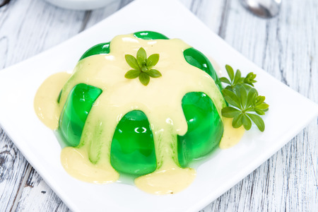 Woodruff Jelly with Vanilla Sauce (on wooden background)の写真素材