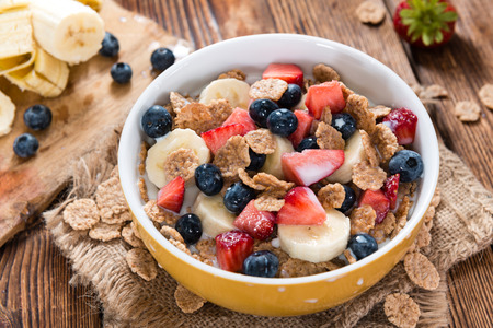 Wholemeal Cornflakes with fresh Fruits on a wooden background