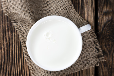 Portion of Milk on a dark wooden background (close-up shot)の写真素材