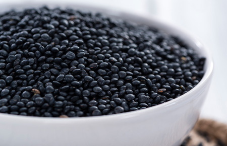 Heap of Black Lentils on wooden background (close-up shot)の写真素材