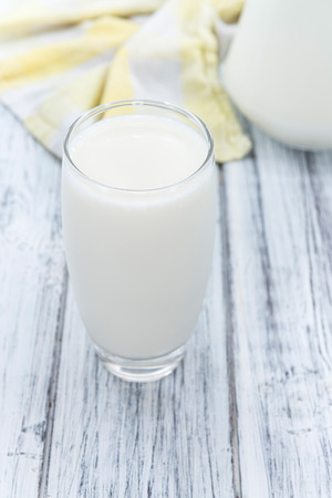 Glass of Milk (close-up shot) on wooden backgroundの写真素材