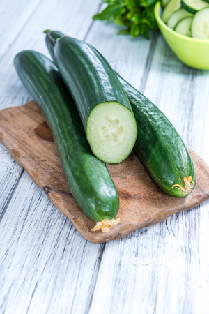 Heap of fresh sliced Cucumbers on an old wooden tableの写真素材