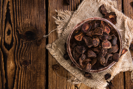 Whole dried Cola Nuts (close-up shot) on wooden backgroundの写真素材