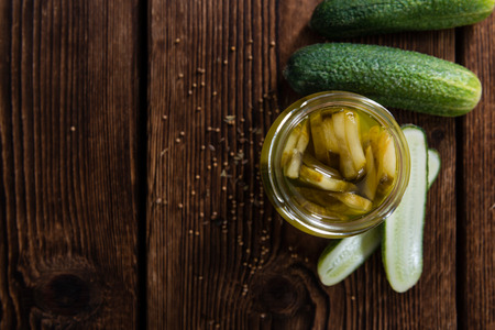 Pickled Cucumbers (sliced) on vintage wooden background (close-up shot)の写真素材